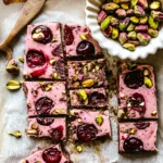 cherry pistachio chocolate yogurt protein bark sliced on parchment with a vintage knife