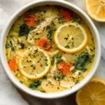 Chicken Lemon Orzo Soup with lemon slices and herbs in white bowl