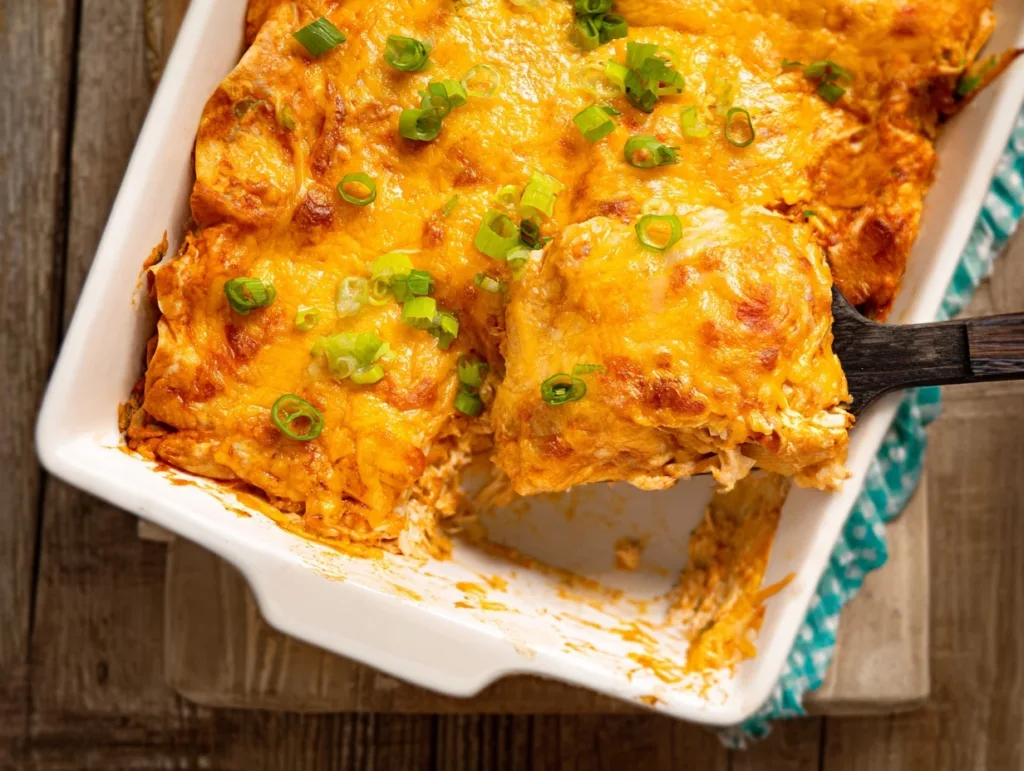 Lazy Chicken Enchilada Bake topped with melted cheese and green onions in a white dish
