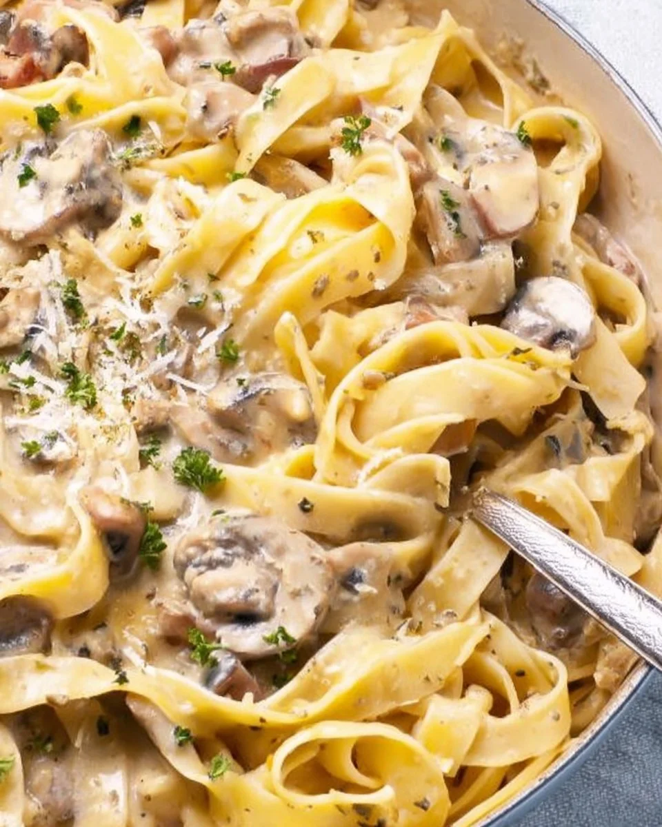 Delicious bowl of truffle pasta garnished with herbs and parmesan cheese.