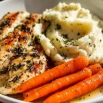 Delicious garlic herb chicken with mashed potatoes and glazed carrots on a plate