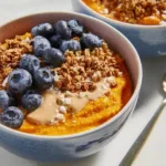 Sweet potato breakfast bowl topped with fruits and nuts for a nutritious morning meal