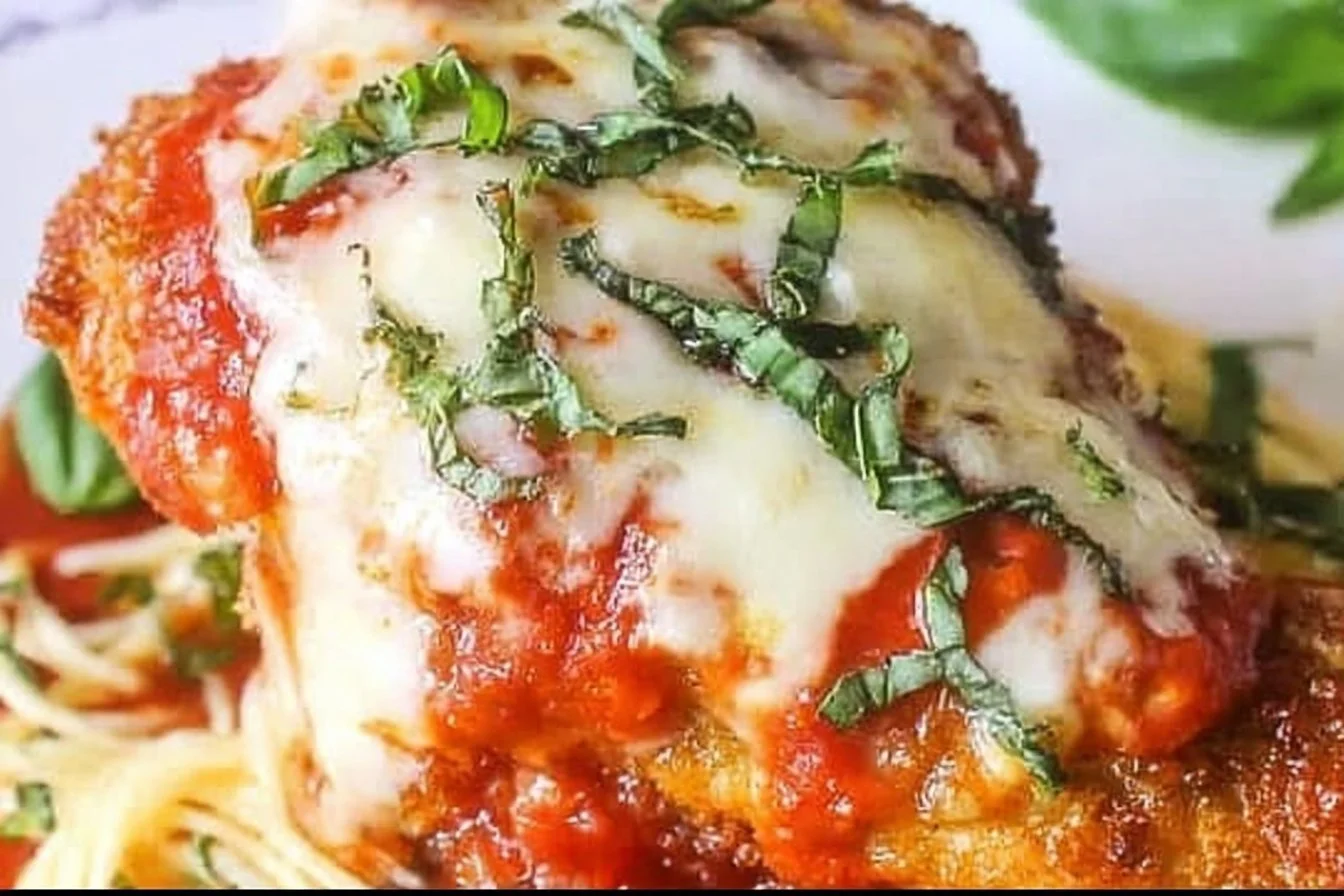 Plate of crispy Chicken Parmesan with marinara sauce and melted cheese