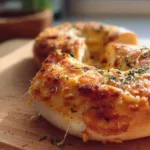 Freshly baked homemade bagels on a cooling rack.