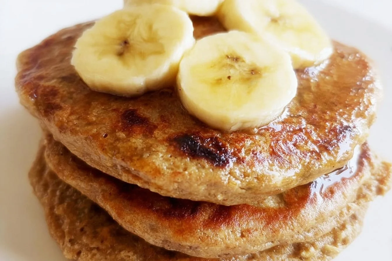 Fluffy banana oatmeal pancakes stacked on a plate