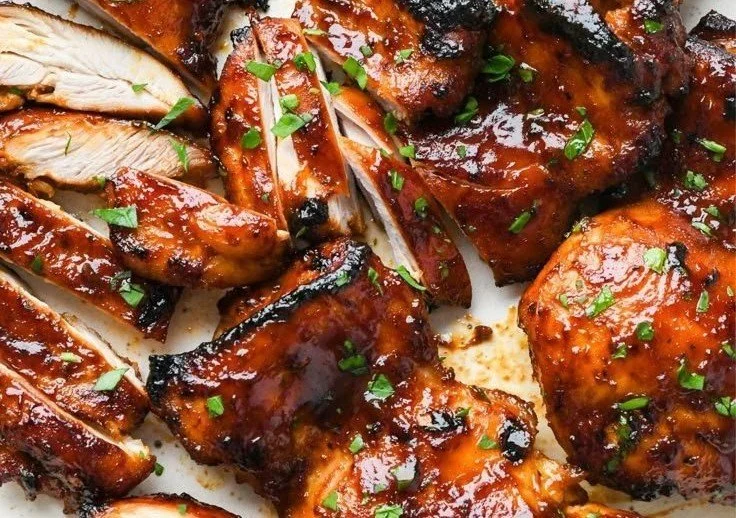 Caramelized BBQ Chicken Thighs sizzling on the grill, ready to serve.