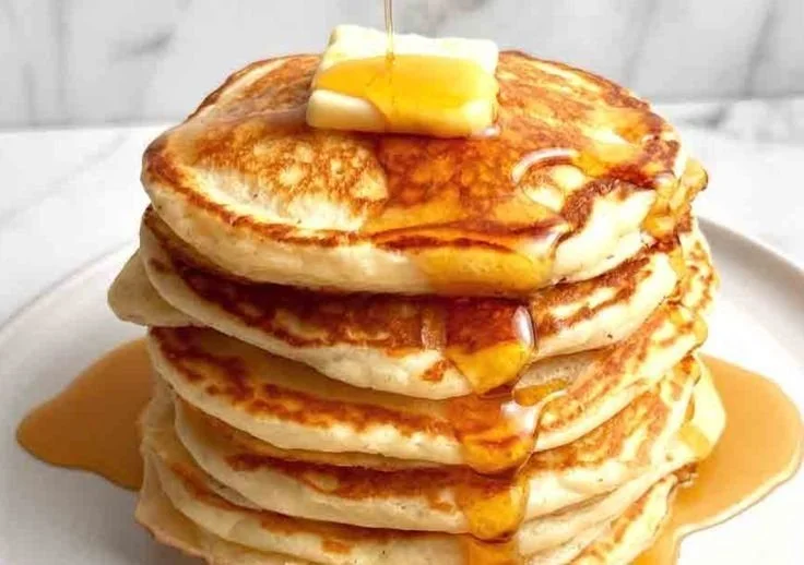 Fluffy Greek yogurt pancakes stacked on a plate with fresh fruit