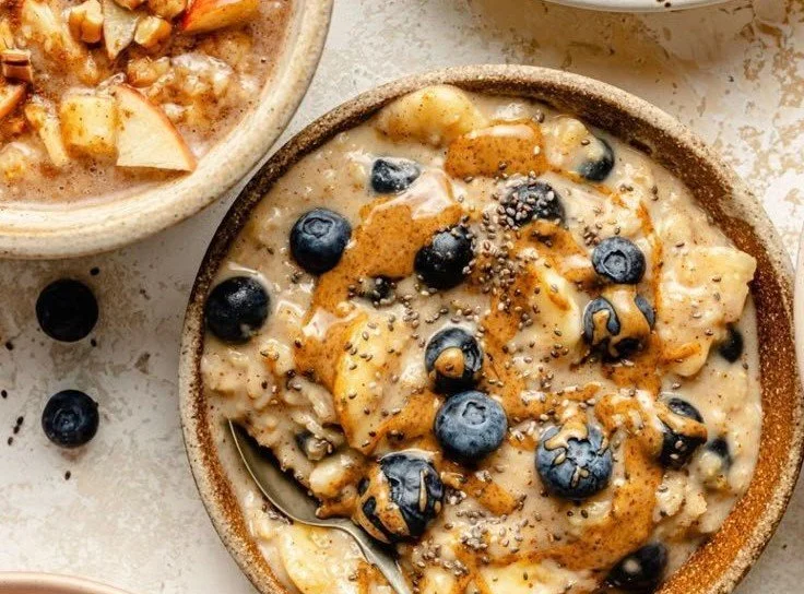 Bowl of homemade oatmeal topped with fresh fruit and nuts.