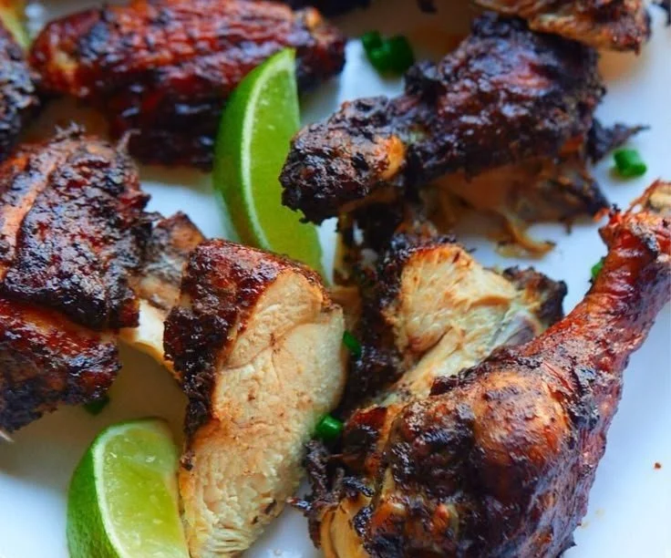 Delicious plate of Jamaican Jerk Chicken garnished with fresh herbs and spices
